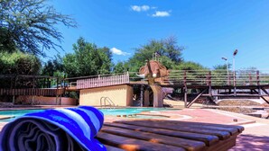 A pool area with a wooden deck, a bridge, and a large elephant statue. - SAMBURU ELEPHANT LODGE (Samburu)