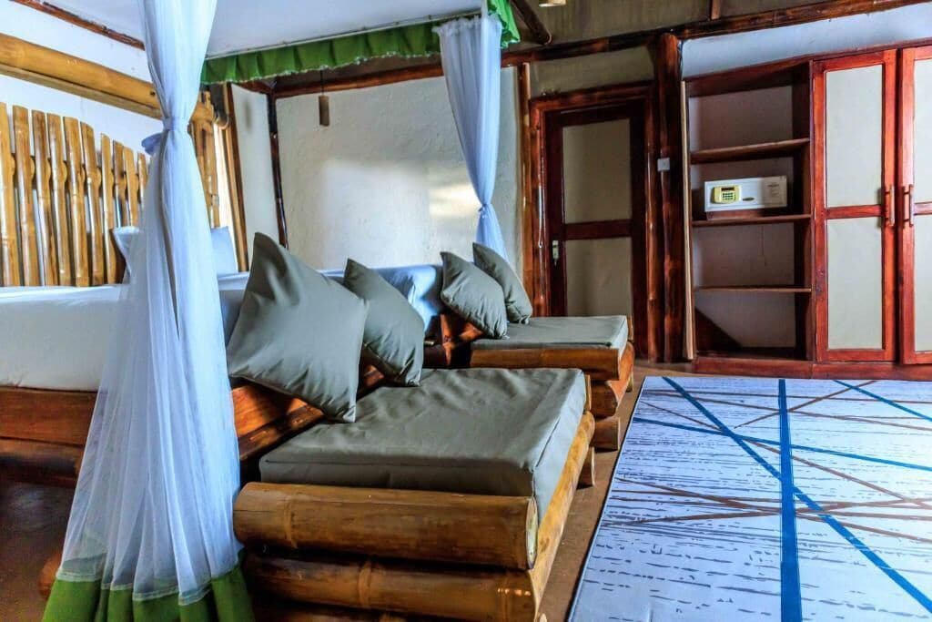 A room with a bed covered by a mosquito net, wooden furniture, and a traditional cabinet.