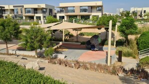 Ein Wohngebiet mit modernen Gebäuden, einem Spielplatz und gepflegten Gärten.