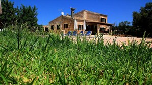 A rustic building with a stone facade, a satellite dish, and a car parked in front. - Can Colau, rural experience in Mallorca, 4 bedrooms and swimming pool (Santa Margalida)