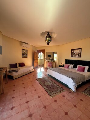 A bedroom with a large bed, a smaller bed, a desk, and a chair. There is a window, a door, and a ceiling light fixture. - Villa Essalah & Spa - Entire Private Villa with Spa, Marrakech (Marrakech)