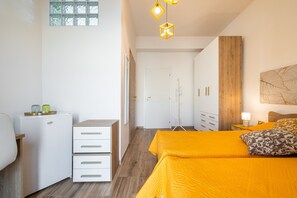 Une chambre à coucher avec un lit, une armoire, un bureau et une fenêtre.