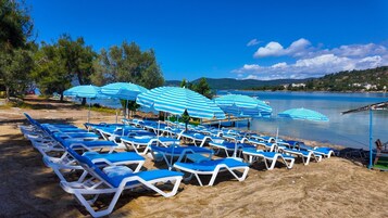 Playa privada, sillas reclinables de playa, sombrillas