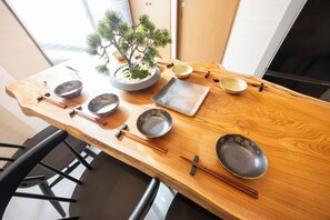 A wooden dining table with chopsticks, bowls, and a bonsai tree. - STAY GATE Nishi-shinjuku gochome.57 ㎡ private hotel. 4min train to Shinjuku Sta. (shibuyaku honmachi)