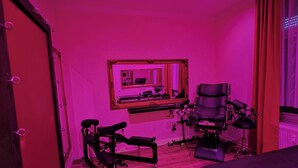 Ein Zimmer mit Spiegelwand, Schreibtisch, Stuhl und Laufband.