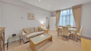 Un salon moderne comprenant un canapé, une table basse et un coin repas avec des chaises et une table.