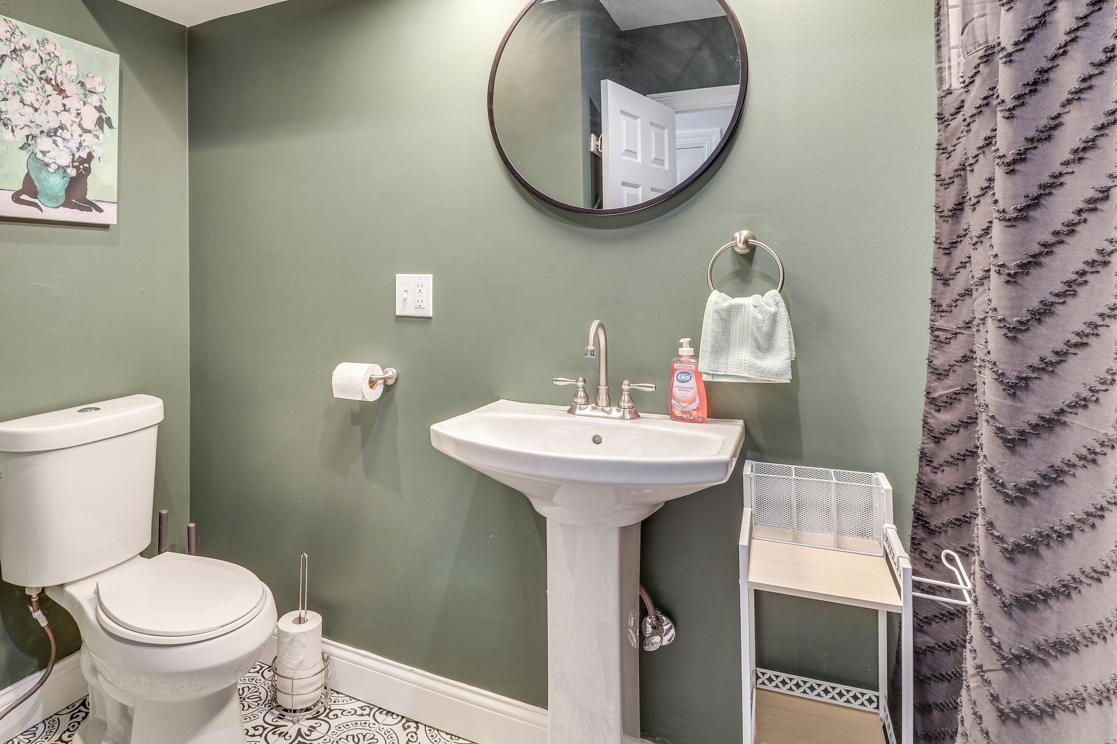 A bathroom with a toilet, sink, and mirror.