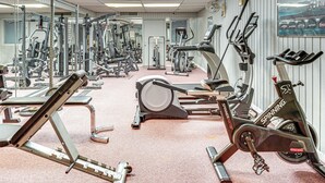 Une salle de sport équipée de divers appareils d’exercice, notamment des tapis de course, des vélos d’appartement et des appareils de musculation.