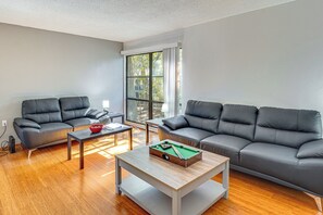 A modern living room with two grey sofas, a wooden coffee table, and a pool table. - Pool Access! UF + Game Day Base in Gainesville (Gainesville)