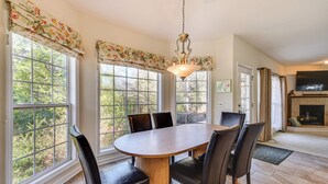 A dining room with a wooden table and chairs, large windows with floral curtains, and a fireplace. - 2 Mi to Pinehurst Resort: Spacious Golf Getaway! (Pinehurst)