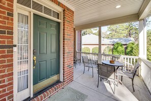 A brick house with a green door, a porch with a table and chairs, and a view of a neighboring house. - 2 Mi to Pinehurst Resort: Spacious Golf Getaway! (Pinehurst)