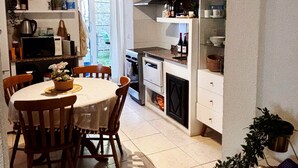 Une cuisine équipée d’une table à manger, de chaises et de divers appareils de cuisine.