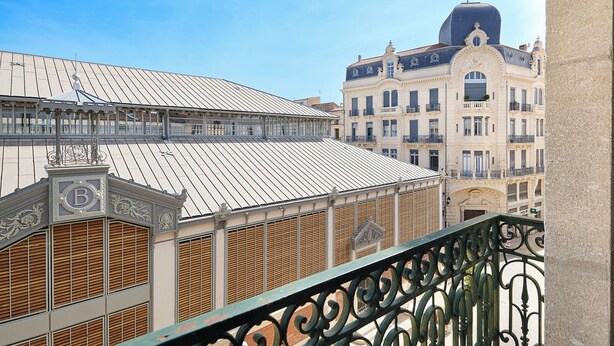 Un edificio con tejado metálico y balcones ornamentados.