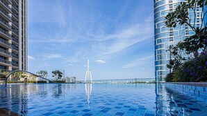 A swimming pool with a clear view of a Ferris wheel and modern buildings in the background. - Spacious 2BR in 52|42, Walk to JBR Beach & Marina (Dubai)