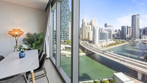 A modern room with a large window, a dining table, and a city view. - Spacious 2BR in 52|42, Walk to JBR Beach & Marina (Dubai)