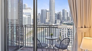 A balcony with a city view, two chairs, a small table, and a potted plant. - Spacious 2BR in 52|42, Walk to JBR Beach & Marina (Dubai)