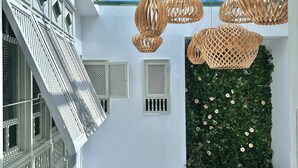 Een modern interieur met een glazen dak, witte muren en een groene wand met planten.