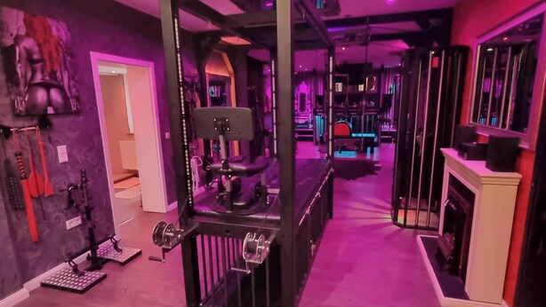 Uma academia em casa com suporte para agachamento, esteiras e diversos equipamentos de ginástica.