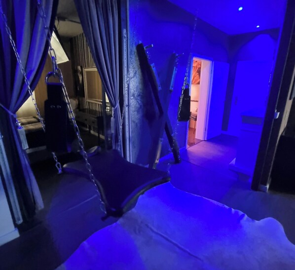 A room with a hanging chair, curtains, and a doorway leading to another room. - Romantic apartment the apartments for erotic hours for two (REmscheid)