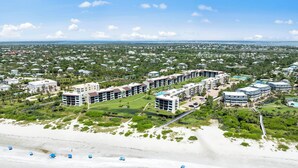 Un resort con varias edificaciones, una playa y cielo despejado.