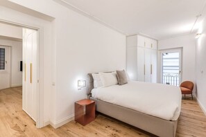 A bedroom with a large bed, a nightstand, a wardrobe, and a chair. - Quiet Elegance Retreat Apartment Trastevere Family-friendly (Roma)