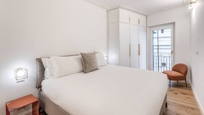 A bedroom with a bed, a nightstand, a wardrobe, and a chair. - Quiet Elegance Retreat Apartment Trastevere Family-friendly (Roma)