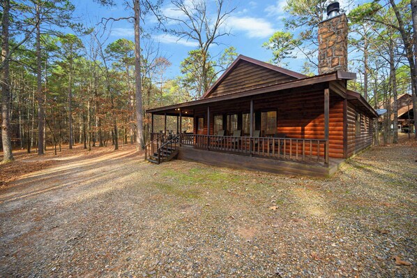 A rustic cabin with a porch, surrounded by a forest. - Lost Key  Cabin Stay for 8 (Broken Bow)