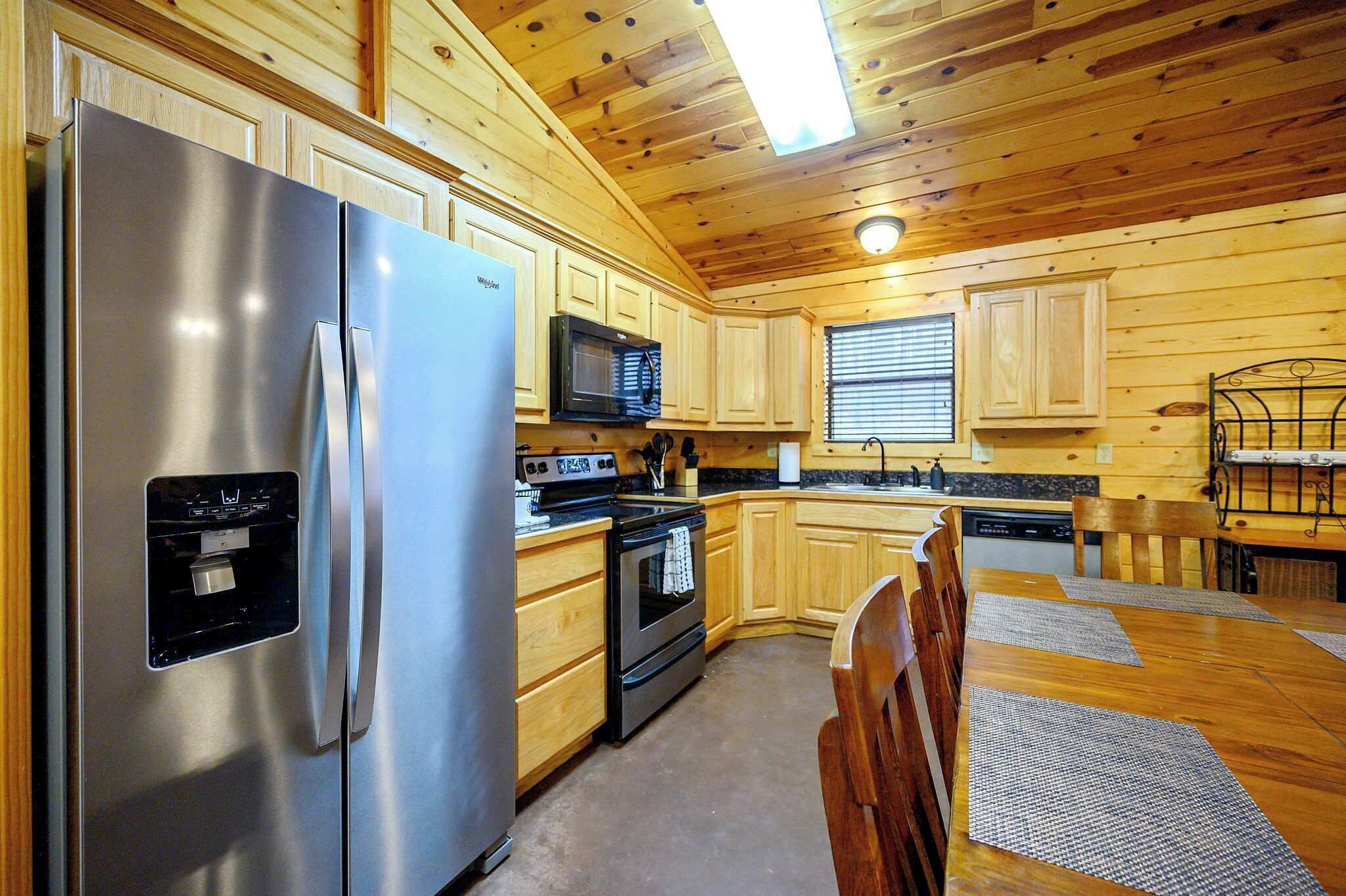 A kitchen with wooden cabinets, stainless steel appliances, a microwave, and a dishwasher.