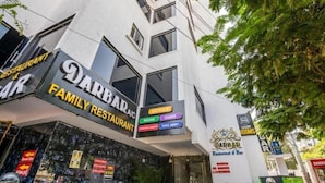 Een gebouw met een bord waarop 'Darbar Family Restaurant' en 'Darbar Luxury Rooms' staan.