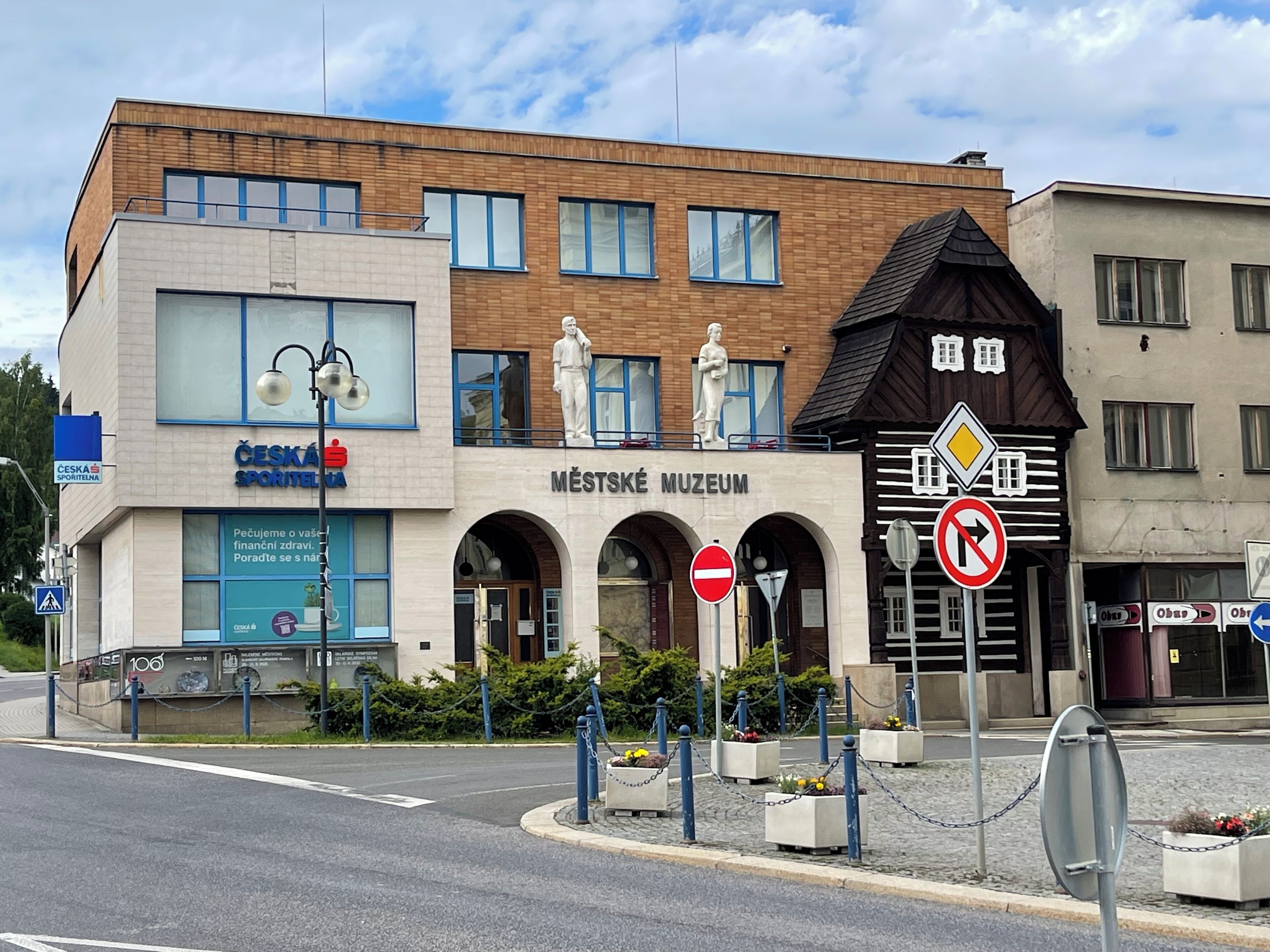 A building with a sign for the Městské Museum and a Česká Sportina sign.