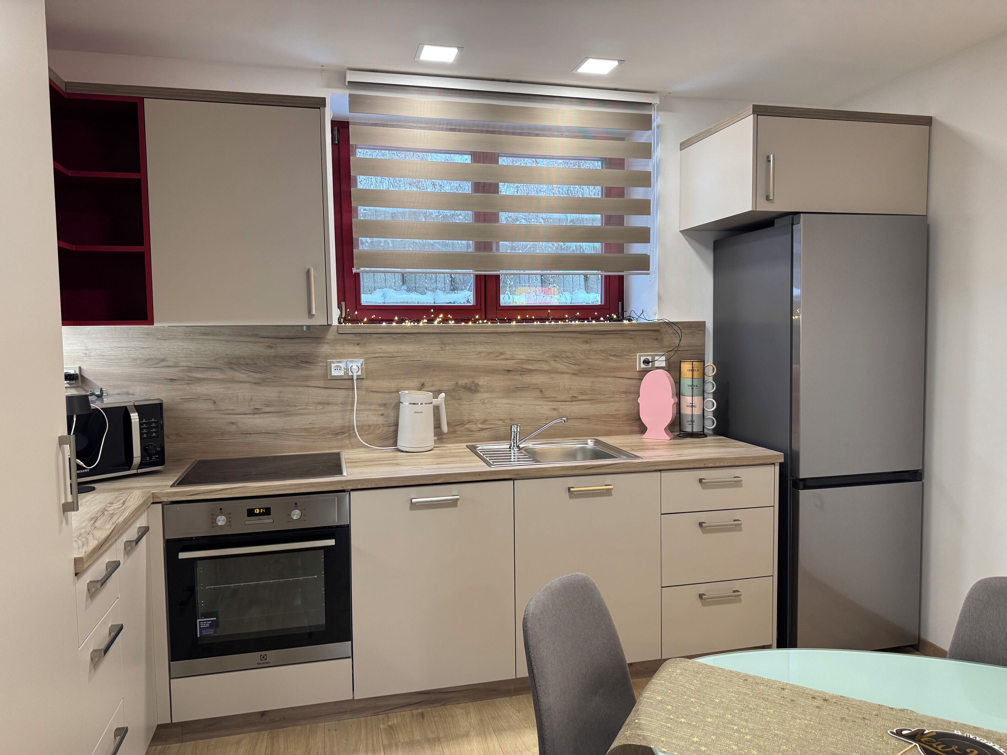A compact kitchen with a microwave, oven, sink, and a refrigerator.