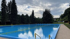 Ein rechteckiger Swimmingpool mit blauem Wasser und gelben Sicherheitsgeländern.