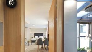 A modern office space with a wooden interior, a conference area, and a view through a glass wall.