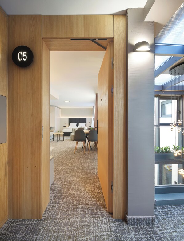 Un espace de bureau moderne avec un aménagement intérieur en bois, une salle de conférence et une vue à travers un mur de verre.