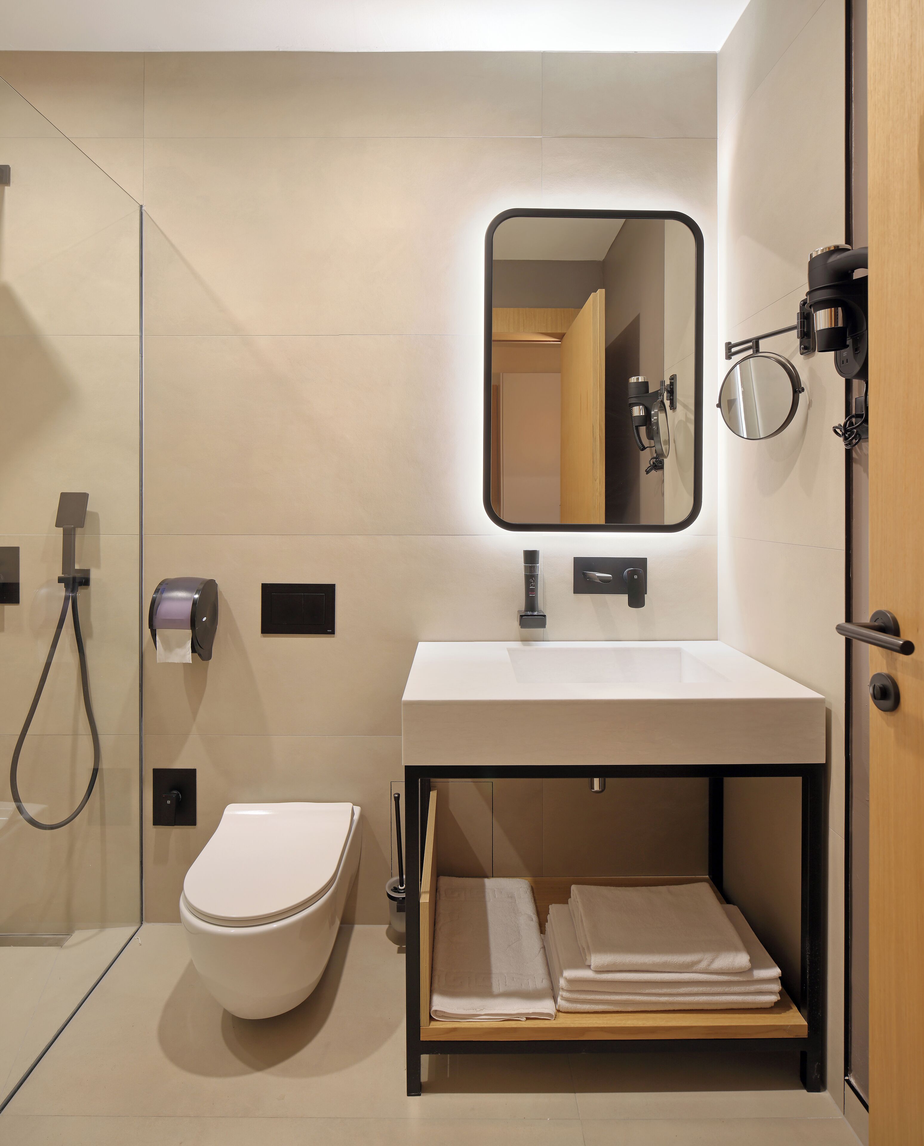A modern bathroom with a toilet, sink, and mirror.
