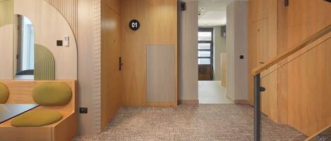 A modern interior with a wooden floor, a staircase, and a door marked with the number 01.