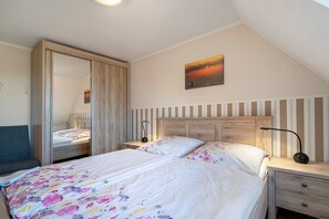 Ein Schlafzimmer mit Bett, Nachttischen, einem Spiegel und einem Bild an der Wand.
