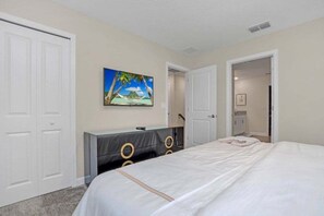 A bedroom with a bed, a dresser, a painting, and two doors. - 9 Bedroom With Everything For Happiness! 9 Home (Kissimmee)