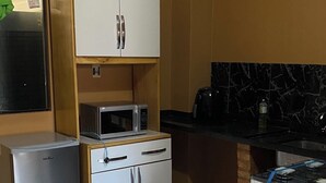 Une cuisine compacte équipée d’un réfrigérateur, d’un four à micro-ondes et d’une cuisinière.
