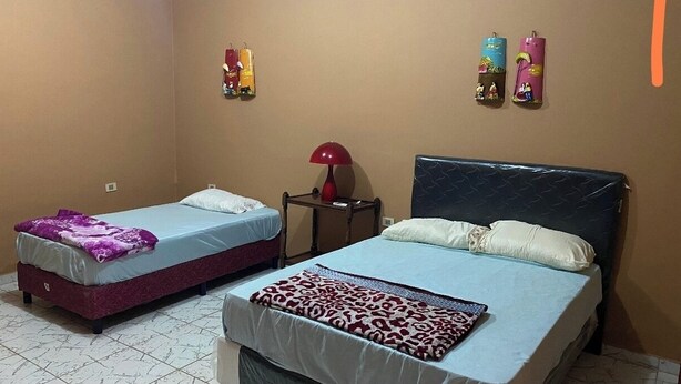 Une chambre d’hôtel avec deux lits, une lampe rouge et des décorations murales.