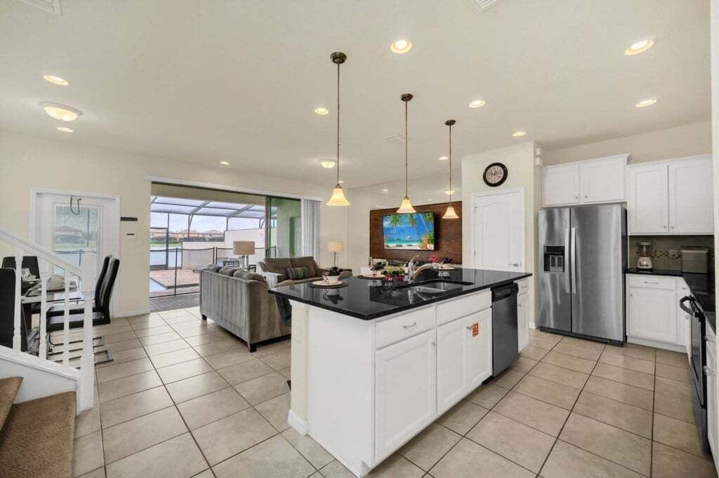 A modern kitchen with a central island, stainless steel appliances, and pendant lighting.