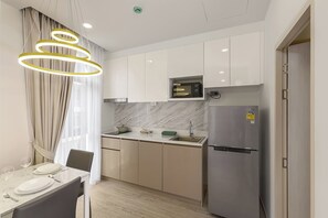 A modern kitchen with white cabinets, a built-in microwave, and a stainless steel refrigerator. - One bedroom Palmetto Condo Karon A309 (Karon)