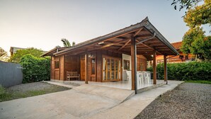A wooden cabin with a covered porch, a bench, and a grill area. - Wooden Retreat Near Lagoa da Conceicao Knu0170 (Florianópolis)