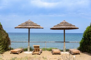On the beach, sun-loungers, beach umbrellas, windsurfing