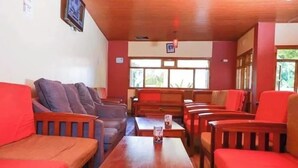 A room with wooden furniture, including sofas and tables, arranged for seating. - Camsupreme Studios Meru  (Meru)