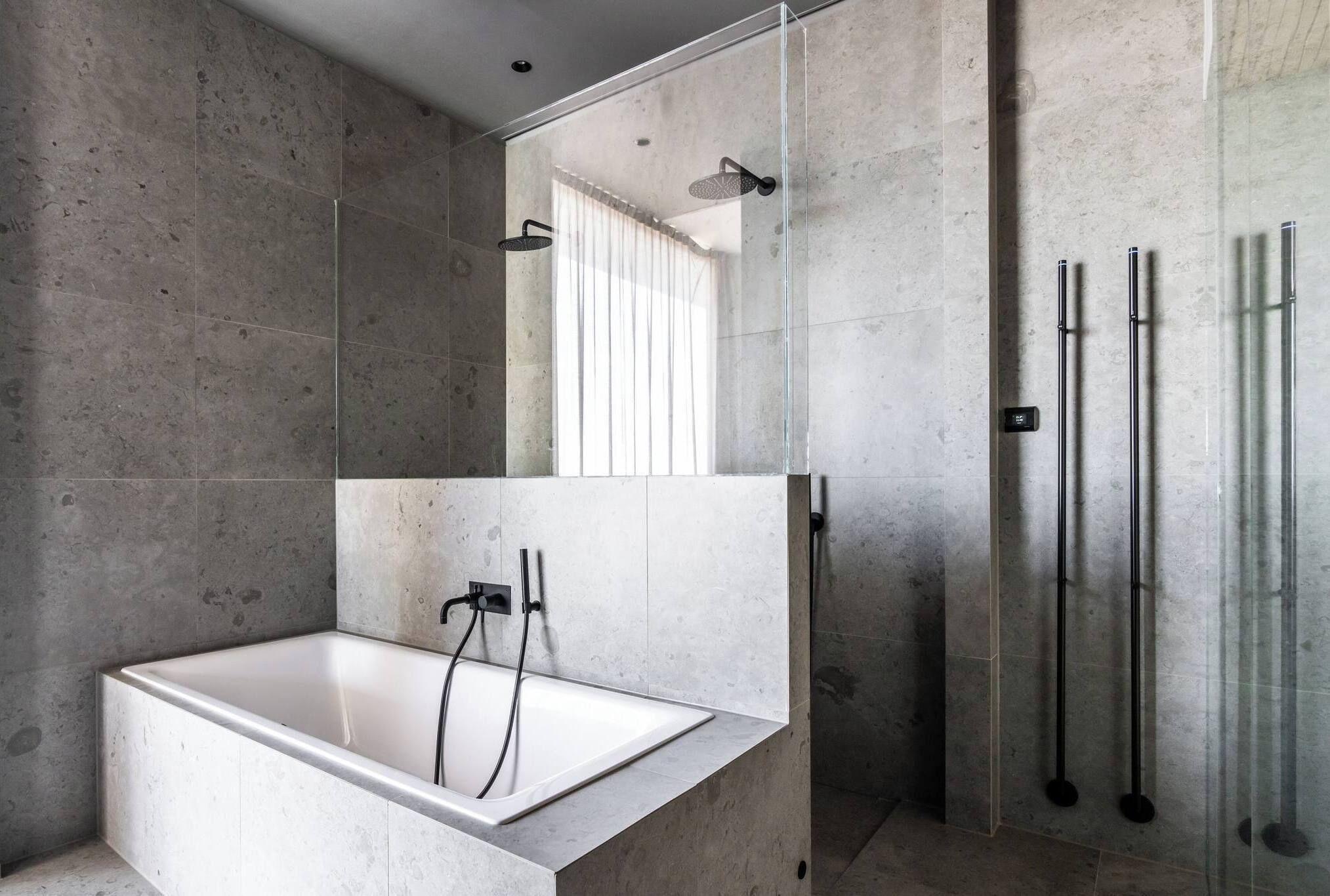 A modern bathroom with a freestanding bathtub, a glass-enclosed shower, and a glass shower door.
