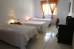 A hotel room with two beds, a desk, and a chair. - Villa La Malcontenta (Alcaucín)