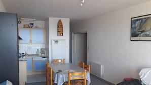 A compact living space with a dining area, kitchenette, and a sofa. - 50 m from the sea, 3rd floor apartment with elevator, 60m2 all comforts (Saint-Jean-de-Monts)