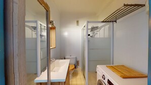 A compact bathroom with a toilet, sink, and a washing machine. - Seafront apartment for 4 people (Canet-en-Roussillon)