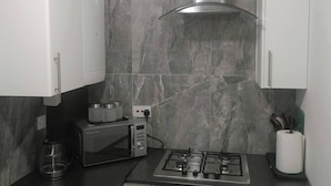 Una cucina moderna con piano cottura a gas, macchina del caffè e forno a microonde.